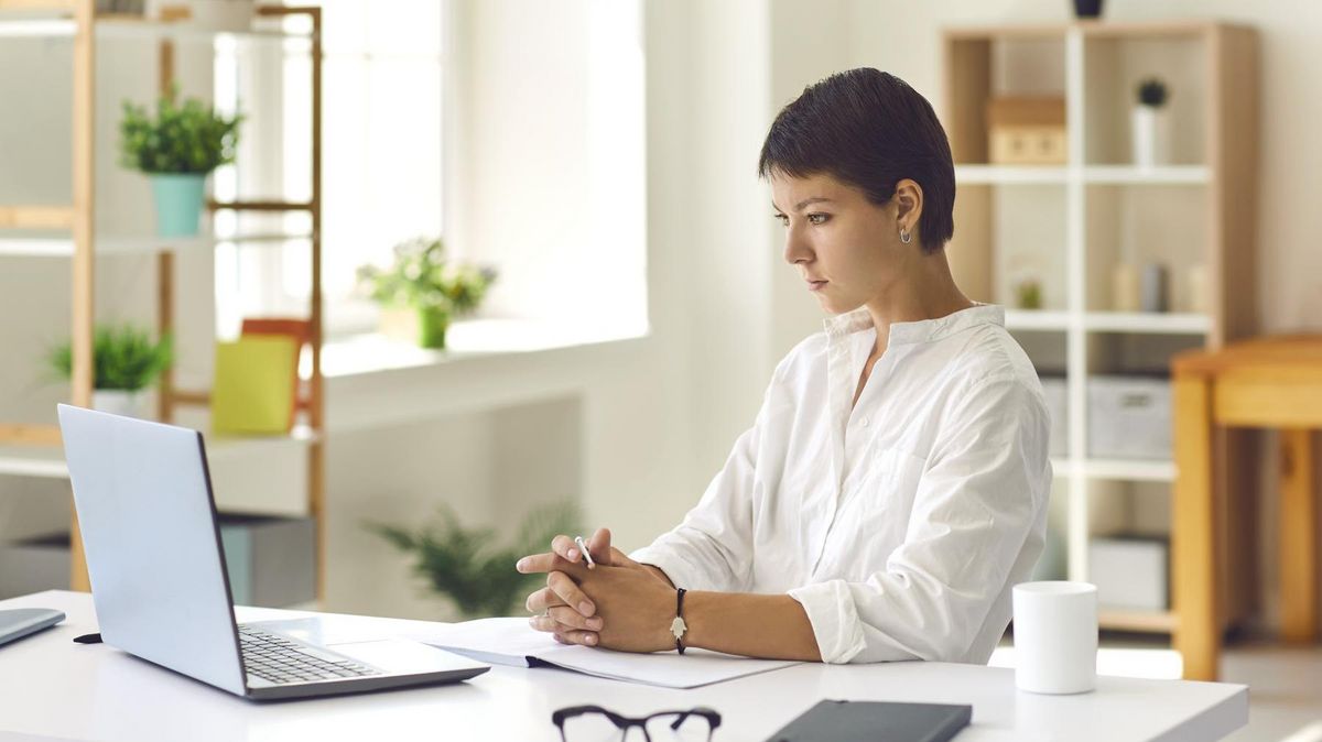zur Vergrößerungsansicht des Bildes: Junge Frau an einem Schreibtisch, auf dem ein Laptop steht
