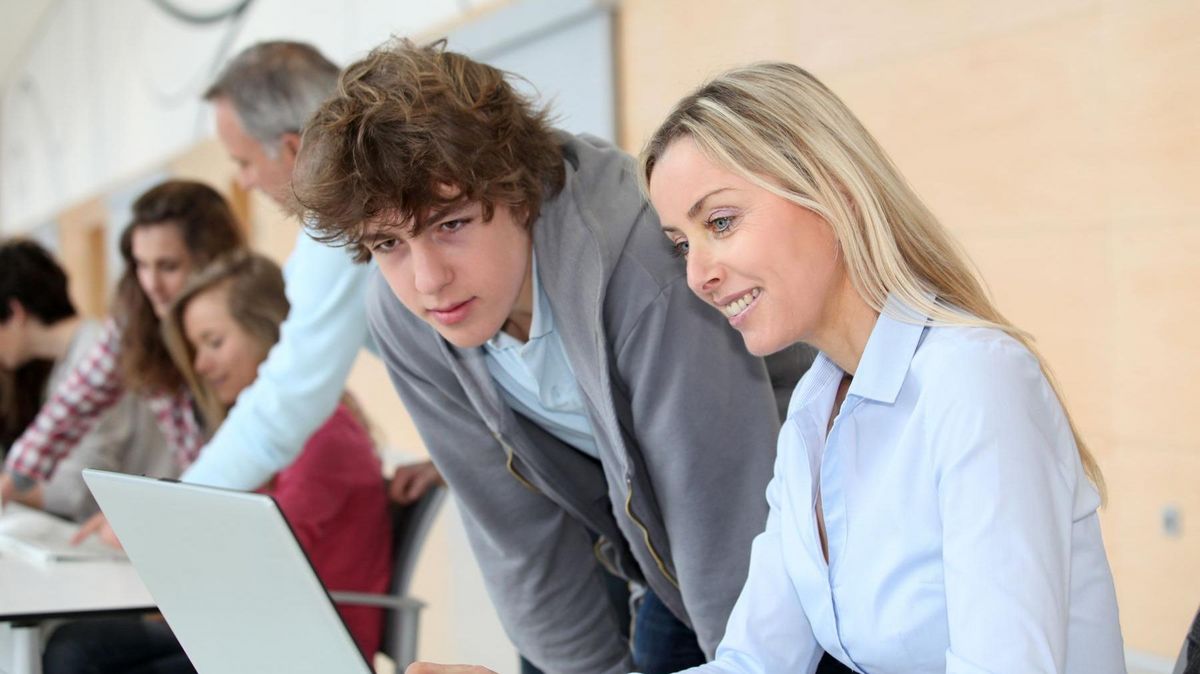 enlarge the image: Teacher and students working on a laptop