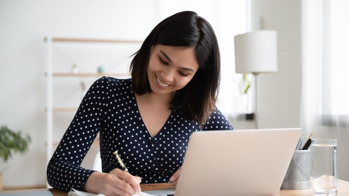 zur Vergrößerungsansicht des Bildes: Eine junge Frau am Schreibtisch, vor ihr ein Laptop