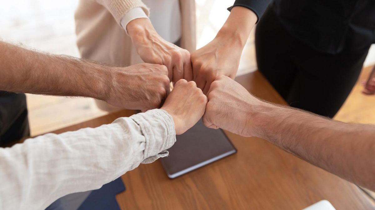 zur Vergrößerungsansicht des Bildes: Fäuste die sich als Teamworkgeste berühren